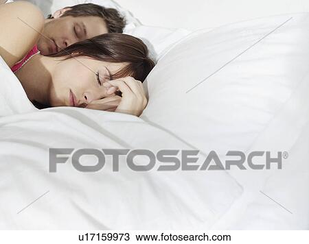 Young couple sleeping in bed View Large Photo Image Stock Image - Young couple sleeping in bed. Fotosearch