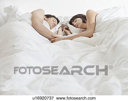 Stock Photo - Young couple sleeping in bed. Fotosearch