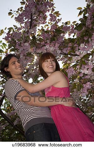 Stock Photo - Young Couple Under a Blossoming Tree. Fotosearch