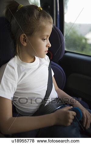 Stock Photo - Young girl wearing seat belt in back seat of car. Fotosearch