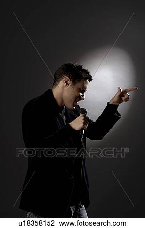 Young man singing in studio View Large Photo Image Stock Image - Young man singing in studio. Fotosearch