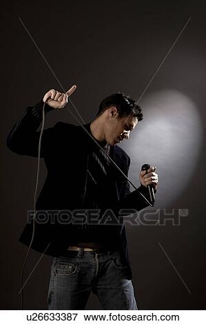 Stock Photo - Young man singing in studio. Fotosearch