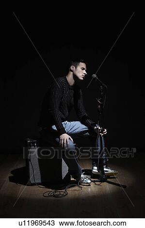 Young man singing on stage View Large Photo Image Stock Image - Young man singing on stage. Fotosearch