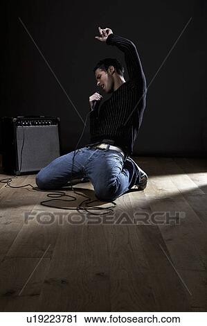 Stock Image - Young man singing on stage. Fotosearch
