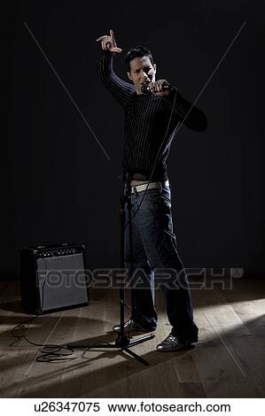 Stock Photography - Young man singing on stage. Fotosearch