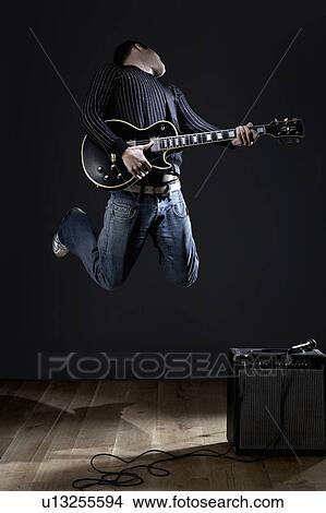 Young man with electric guitar jumping on stage View Large Photo Image Picture - Young man with electric guitar jumping on stage. Fotosearch