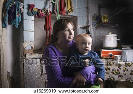 Stock Photo - Young mother and child sit in kitchen interior. Fotosearch