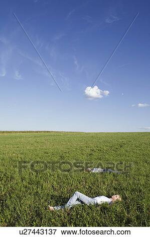 Stock Photo - Young People Lying in Meadow. Fotosearch