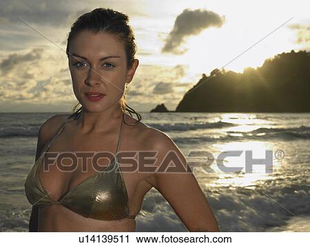 Stock Image - Young Woman at Beach at Sunset. Fotosearch