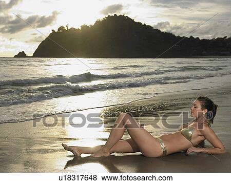 Stock Photo - Young Woman at Beach at Sunset. Fotosearch