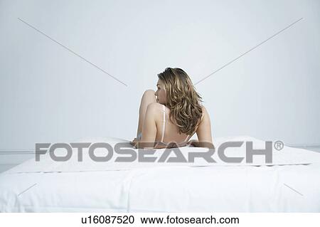 Young woman in underwear lying on bed, back view View Large Photo Image Stock Image - Young woman in underwear lying on bed, back view. Fotosearch