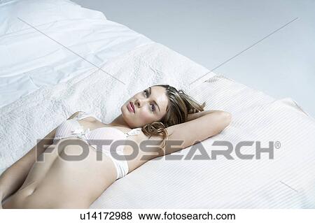 Young woman in underwear lying on bed, elevated view View Large Photo Image Stock Photo - Young woman in underwear lying on bed, elevated view. Fotosearch