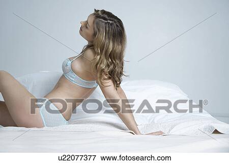 Young woman in underwear lying on bed, back view View Large Photo Image Stock Photo - Young woman in underwear lying on bed, back view. Fotosearch