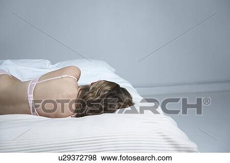 Young woman in underwear lying on bed, back view View Large Photo Image Stock Photo - Young woman in underwear lying on bed, back view. Fotosearch
