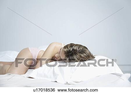 Young woman in underwear lying on bed, close-up View Large Photo Image Stock Photograph - Young woman in underwear lying on bed, close-up. Fotosearch