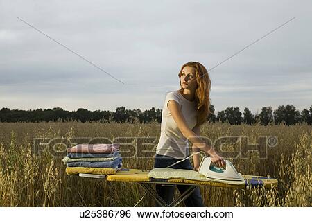 Stock Photograph - Young Woman Ironing in a Field. Fotosearch