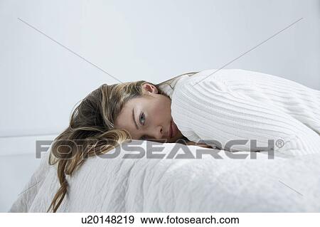 Young woman lying on bed, close-up View Large Photo Image Stock Photo - Young woman lying on bed, close-up. Fotosearch