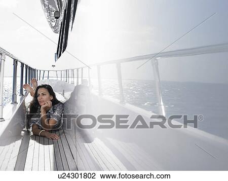 Young woman lying on deck of yacht View Large Photo Image Stock Image - Young woman lying on deck of yacht. Fotosearch