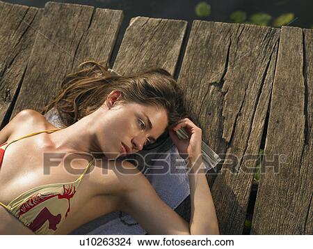 Young woman lying on jetty, view from above View Large Photo Image Picture - Young woman lying on jetty, view from above. Fotosearch