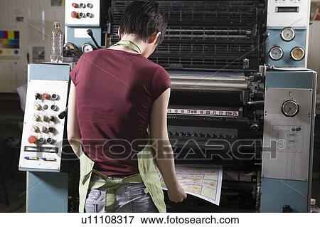 Stock Photo - Young woman operating printing press. Fotosearch