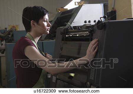 Stock Photo - Young woman operating printing press. Fotosearch