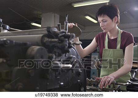 Stock Photo - Young woman operating printing press. Fotosearch