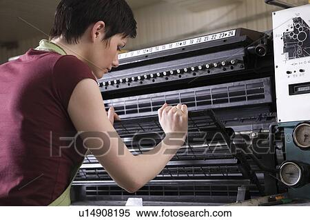 Young woman operating printing press View Large Photo Image Stock Photography - Young woman operating printing press. Fotosearch
