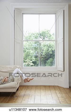 Stock Photo - Young woman relaxing on sofa. Fotosearch