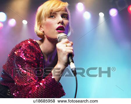Young Woman Singing in Concert on stage, low angle view View Large Photo Image Stock Photo - Young Woman Singing in Concert on stage, low angle view. Fotosearch
