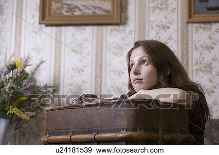 Stock Photo - Young woman sits at desk in Russian apartment. Fotosearch