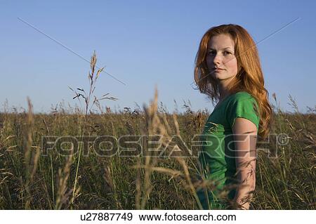 Young Woman Standing in a Field of Tall Grass View Large Photo Image Stock Photo - Young Woman Standing in a Field of Tall Grass. Fotosearch