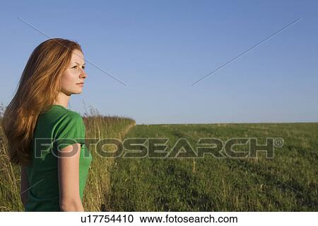 Young Woman Standing in a Field View Large Photo Image Stock Image - Young Woman Standing in a Field. Fotosearch