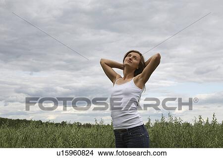 Young woman standing on field View Large Photo Image Picture - Young woman standing on field. Fotosearch