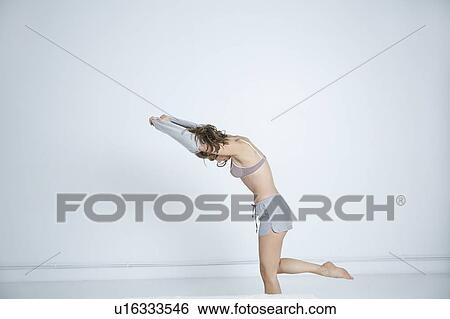Young woman undressing in bedroom View Large Photo Image Stock Photograph - Young woman undressing in bedroom. Fotosearch