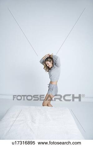 Young woman undressing in bedroom View Large Photo Image Stock Photography - Young woman undressing in bedroom. Fotosearch