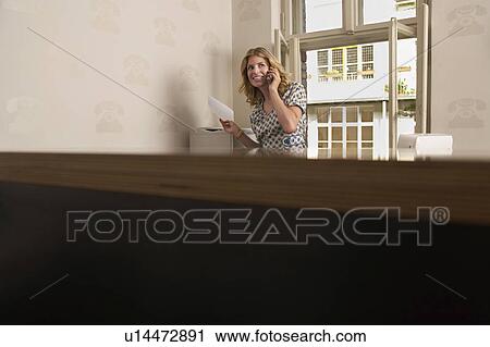 Young woman using phone in bare office View Large Photo Image Stock Image - Young woman using phone in bare office. Fotosearch