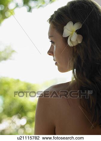 Stock Image - Young Woman with Flower in Hair. Fotosearch