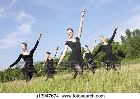 Picture - Young women dance in a field. Fotosearch