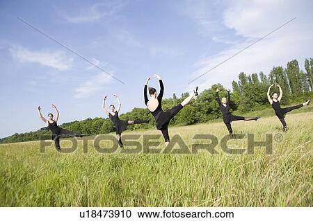 Stock Image - Young women dance in a field. Fotosearch