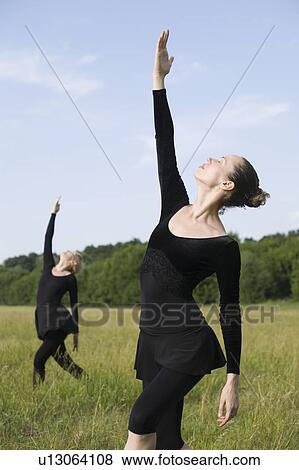 Stock Photo - Young women stretch in a field. Fotosearch