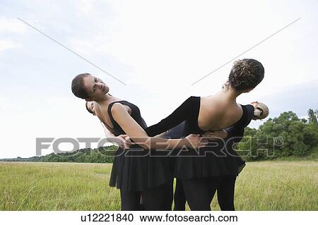 Young women support each other and lean backwards View Large Photo Image Stock Image - Young women support each other and lean backwards. Fotosearch
