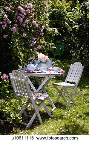 Stock Photography - Alfresco teatime under pink climbing roses.. Fotosearch