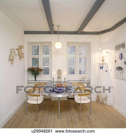 Aluminium table and retro chairs in fifties dining room with beamed ceiling and wooden flooring View Large Photo Image Stock Image - Aluminium table and retro chairs in fifties dining room with beamed ceiling and wooden flooring. Fotosearch