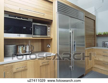 American style stainless steel fridge freezer beside tambour shutter raised to reveal microwave oven and steamer View Large Photo Image Stock Photo - American style stainless steel fridge freezer beside tambour shutter raised to reveal microwave oven and steamer. Fotosearch