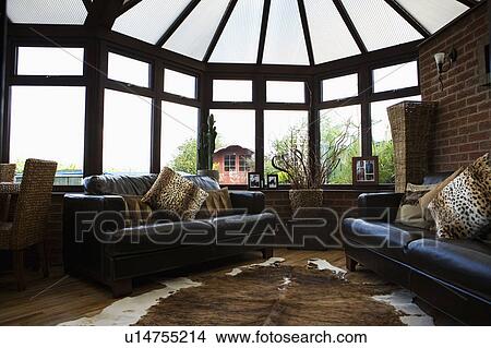 Stock Photo Of Animalprint Cushions On Black Leather Sofas In Animalprint Cushions On Black Leather Sofas In Conservatory Living Room