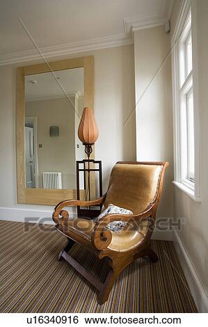 Antique beige leather and wood armchair on cream landing with large mirror on wall and striped carpet View Large Photo Image Stock Photograph - Antique beige leather and wood armchair on cream landing with large mirror on wall and striped carpet. Fotosearch