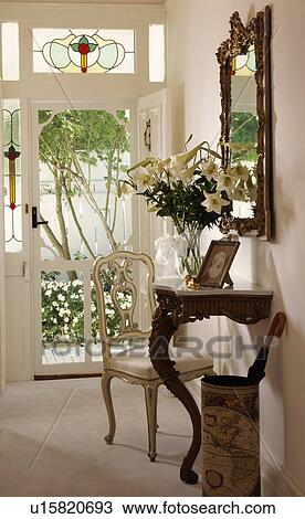 Antique chair and marble-topped mahogany console table in traditional white hall View Large Photo Image Stock Image - Antique chair and marble-topped mahogany console table in traditional white hall. Fotosearch