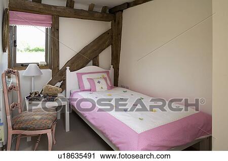 Antique chair and single bed with pink quilt in small beamed country bedroom View Large Photo Image Stock Image - Antique chair and single bed with pink quilt in small beamed country bedroom. Fotosearch