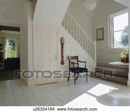 Antique chair on white tiled floor in sunny white hall View Large Photo Image Picture - Antique chair on white tiled floor in sunny white hall . Fotosearch