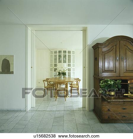 Stock Photo - Antique cupboard in modern white hall with view of dining room. Fotosearch